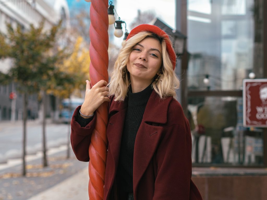 Femme souriante en béret rouge dans la rue