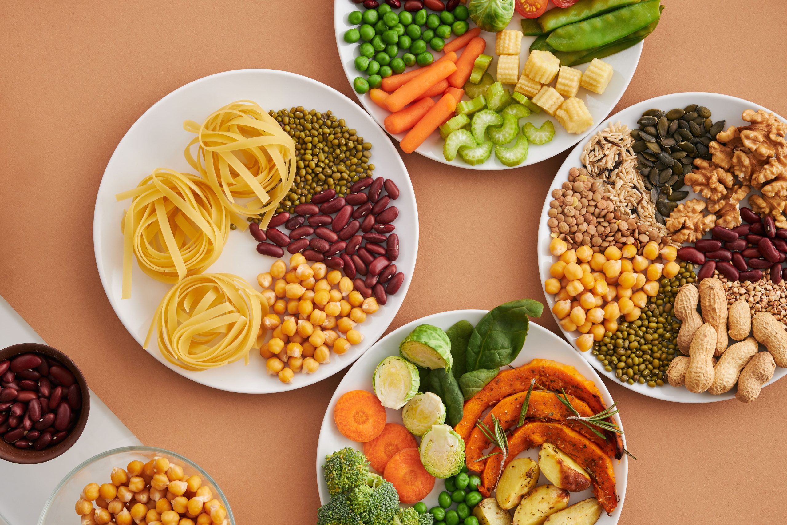 Légumineuses, légumes et noix sur assiettes blanches