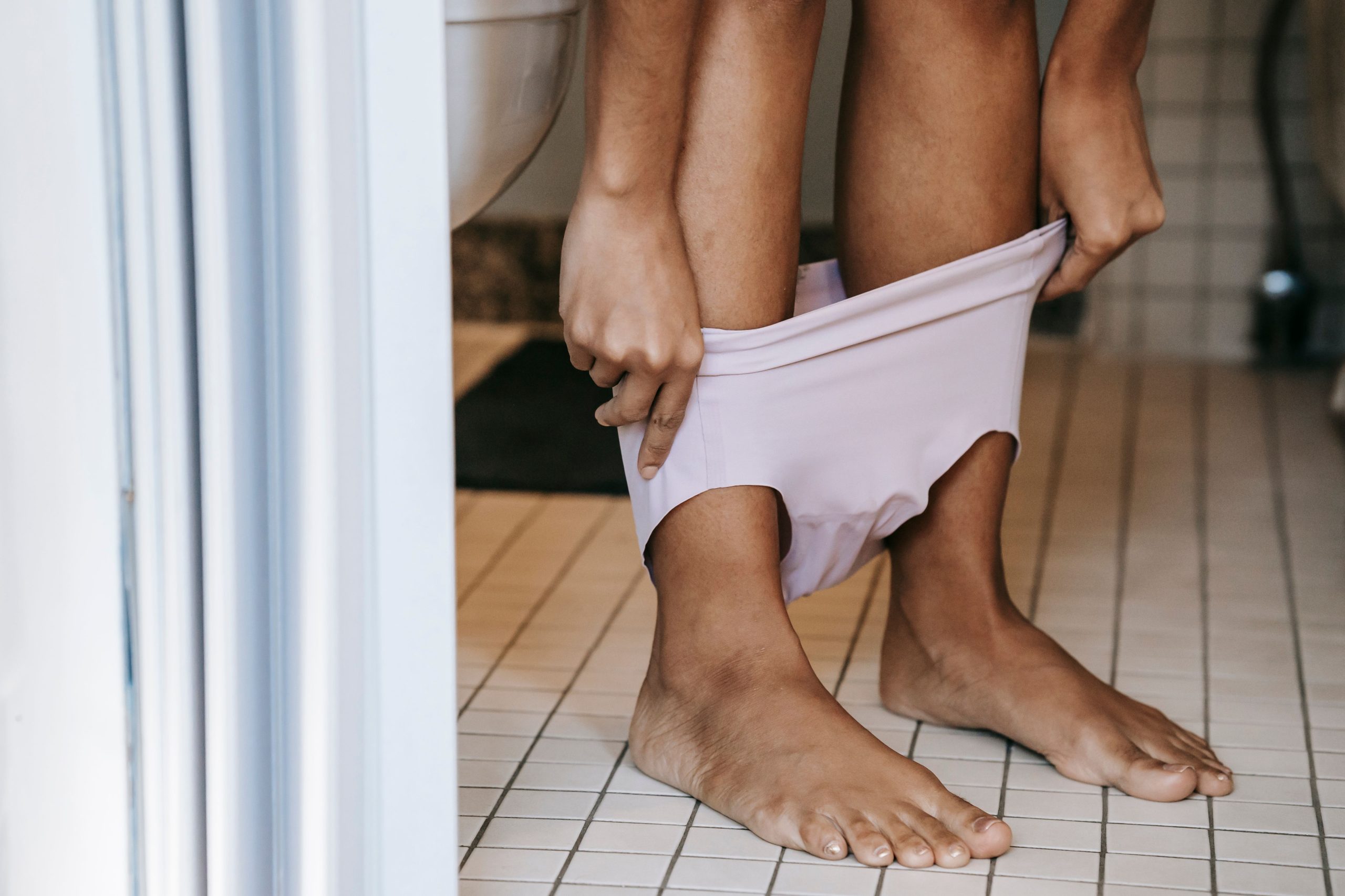 Jeune femme pieds nus près des toilettes